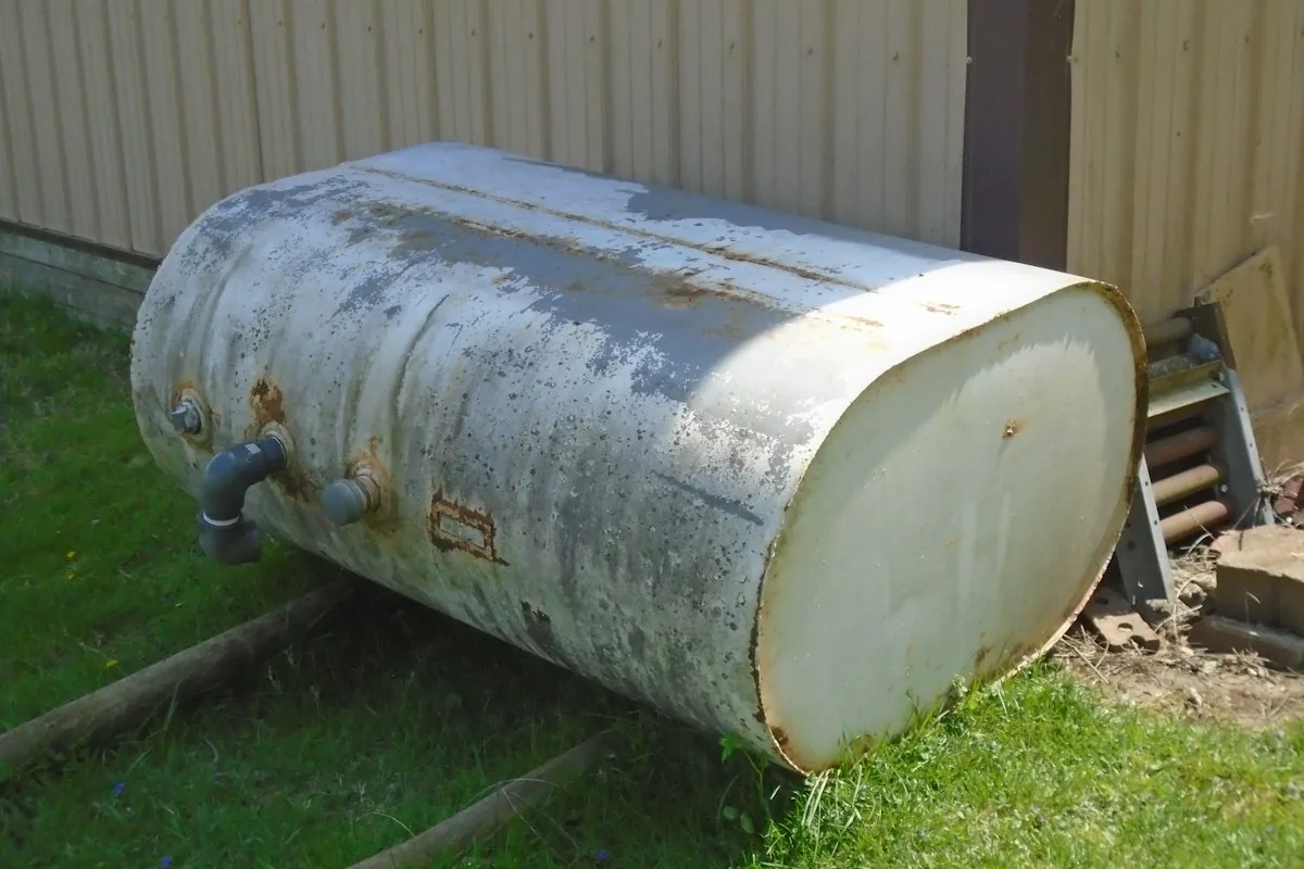 Rusted residential heating oil tank removed from a property in Moncton, New Brunswick, showing a corroded shell and fuel line fittings