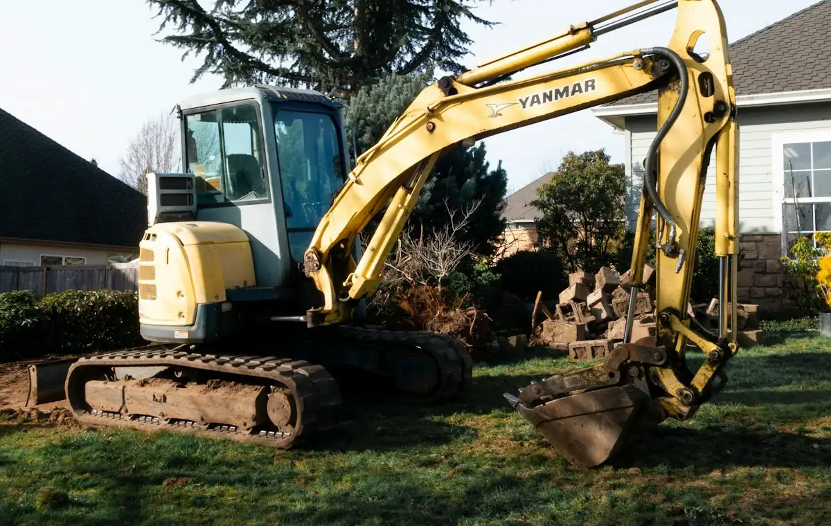 Mini excavator positioned beside a house to expose a buried heating oil tank in Moncton, New Brunswick